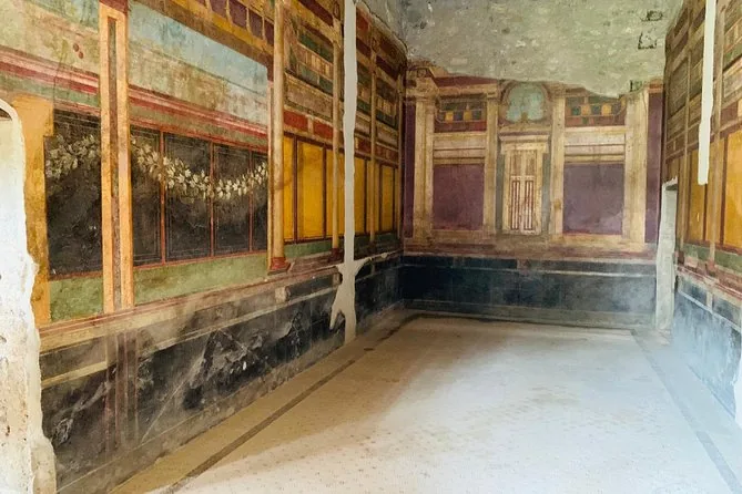 Una estancia romana con paredes pintadas en paneles rojos, amarillos y negros